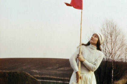 Frau hält rote Fahne im Freien