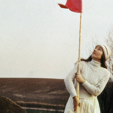 Frau hält rote Fahne im Freien